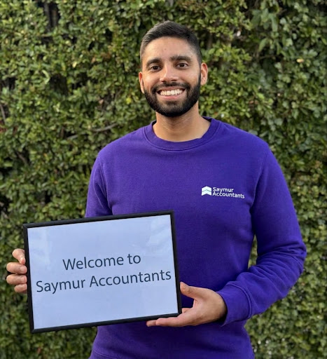 A member of the Saymur team holding a welcome sign for Saymur Accountants